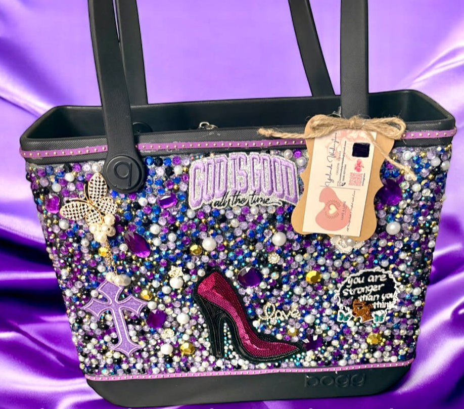 Decorative handbag with embellishments on a purple satin background, featuring the brand 'Luxelovebyyolanda'.